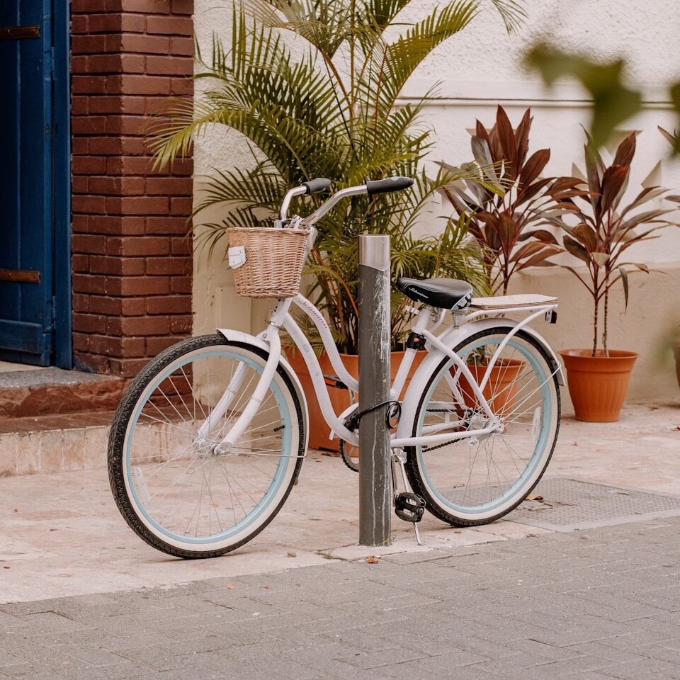 a white bicycle parked on the side of a street